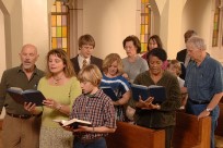 A group of people reading books in a church

Description automatically generated