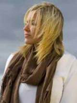 A person with blonde hair wearing a scarf

Description automatically generated